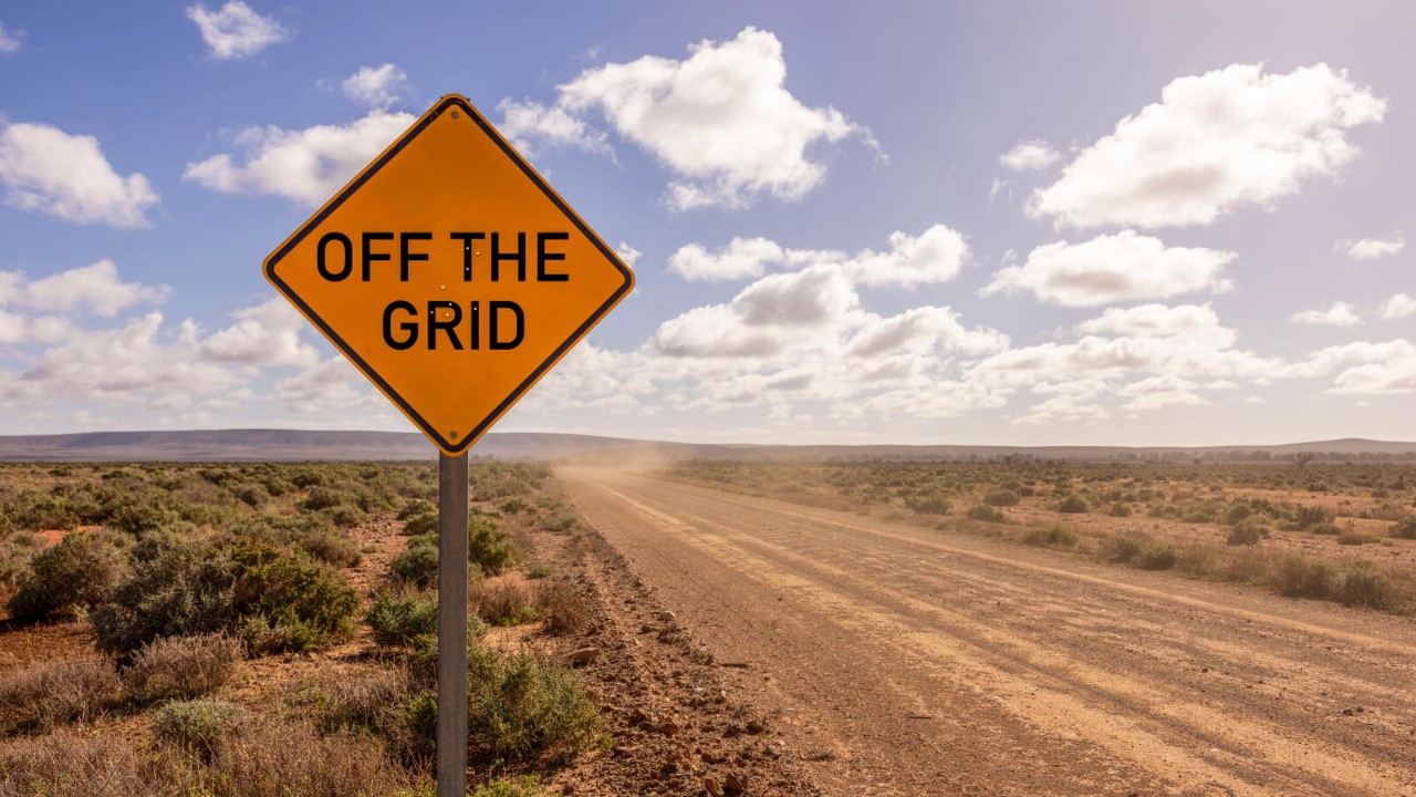 Desert road with "Off the grid" road sign